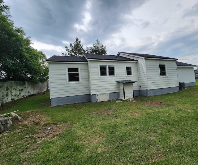 rear view of house featuring a lawn