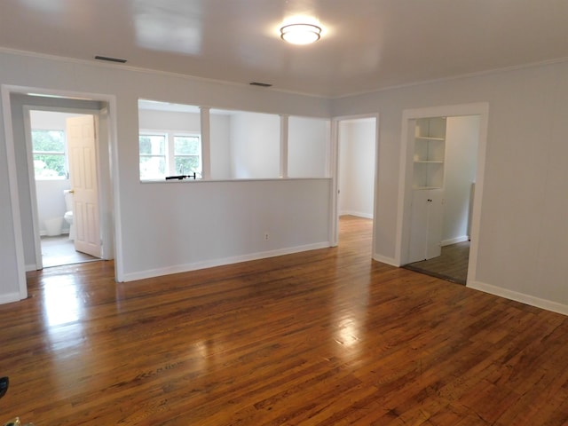 spare room featuring dark hardwood / wood-style floors and crown molding