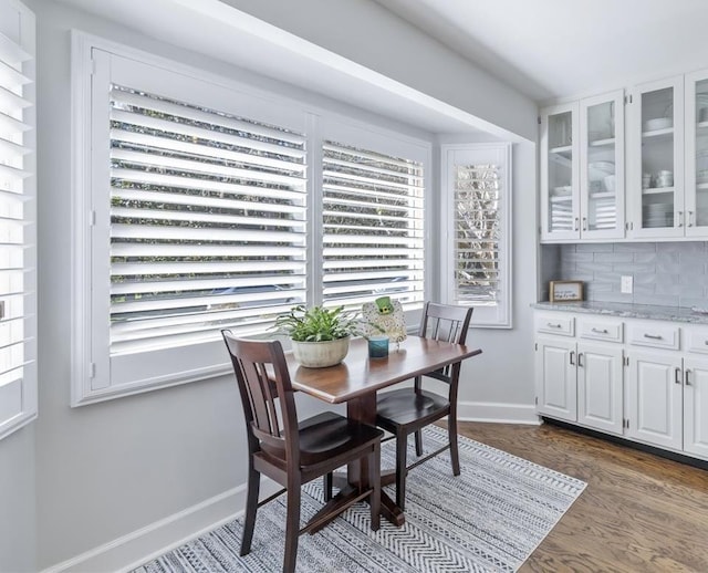 dining space featuring dark wood-style floors and baseboards