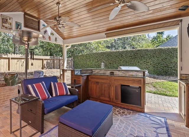 view of patio featuring area for grilling, ceiling fan, an outdoor hangout area, grilling area, and fence