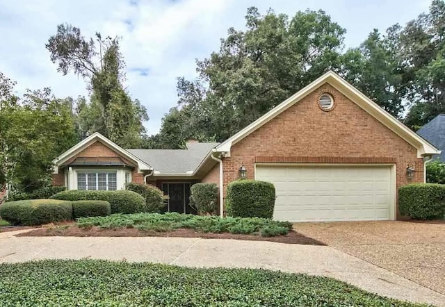 single story home with a garage, concrete driveway, and brick siding