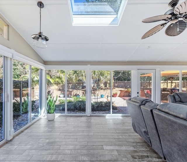 sunroom / solarium with vaulted ceiling with skylight and a ceiling fan