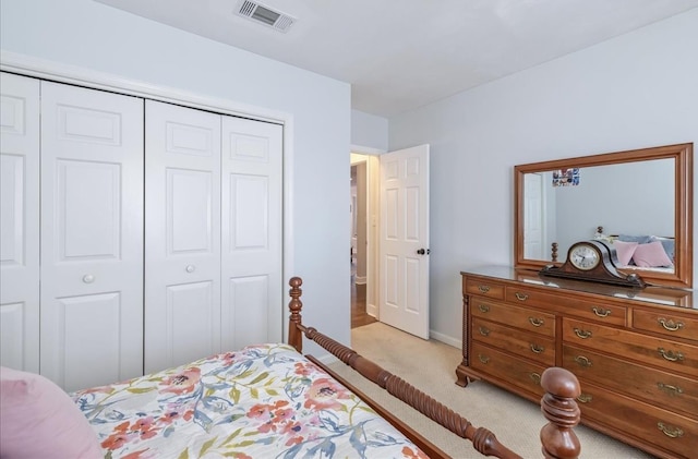 bedroom with a closet, visible vents, light carpet, and baseboards