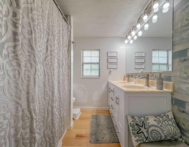 7420 Hickock Ct, Tallahassee, FL 32311 - bathroom with healthy amount of natural light, wood finished floors, double vanity, a textured ceiling, and curtained shower