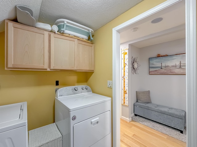 7420 Hickock Ct, Tallahassee, FL 32311 - laundry area featuring cabinet space, light wood-type flooring, independent washer and dryer, and a textured ceiling