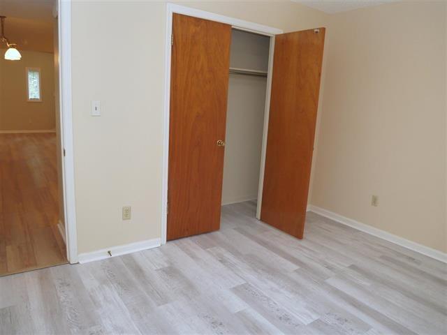 unfurnished bedroom featuring light wood-type flooring and a closet