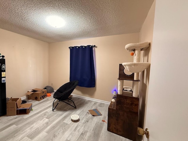 interior space with a textured ceiling and hardwood / wood-style flooring