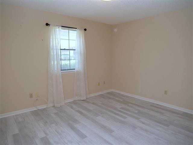 unfurnished room with light wood-type flooring