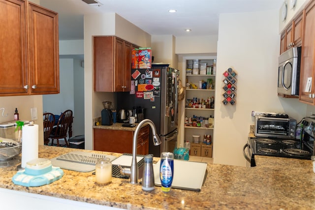 kitchen featuring light stone countertops and appliances with stainless steel finishes