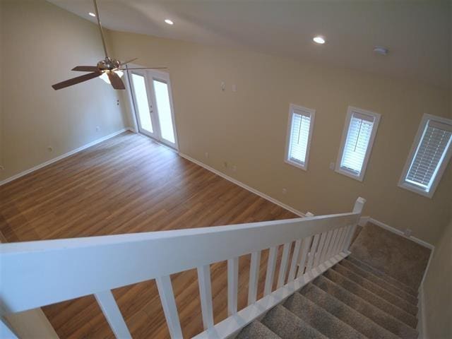 stairs with hardwood / wood-style floors and ceiling fan