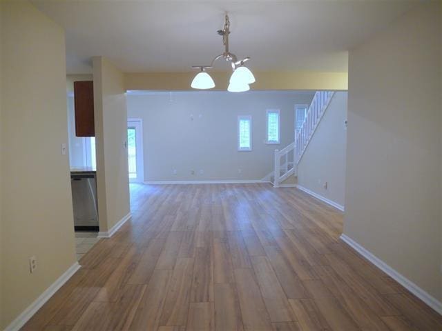 unfurnished dining area featuring hardwood / wood-style flooring and a chandelier