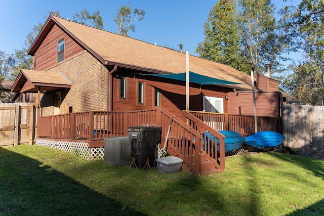 rear view of house featuring a lawn, a wooden deck, and cooling unit