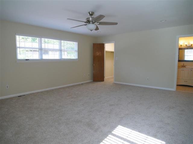 unfurnished room with light carpet, sink, and ceiling fan