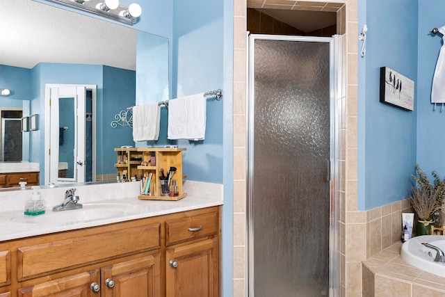 bathroom featuring shower with separate bathtub and vanity