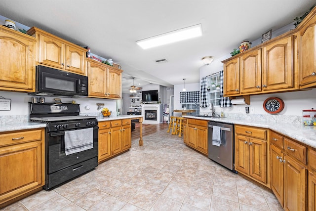 kitchen with hanging light fixtures, ceiling fan, light tile patterned floors, and black appliances