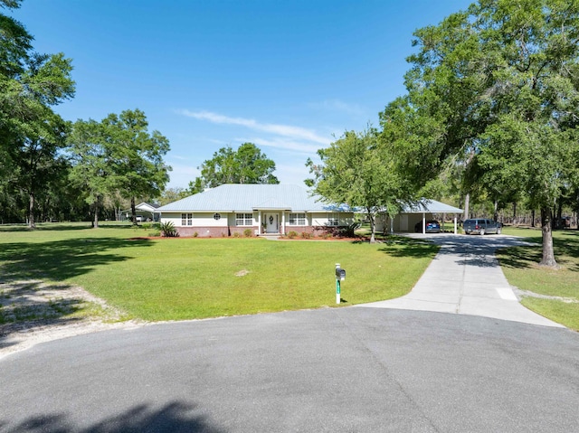 ranch-style home featuring a carport and a front yard