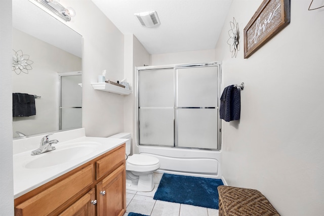 full bathroom with vanity, tile patterned floors, combined bath / shower with glass door, and toilet