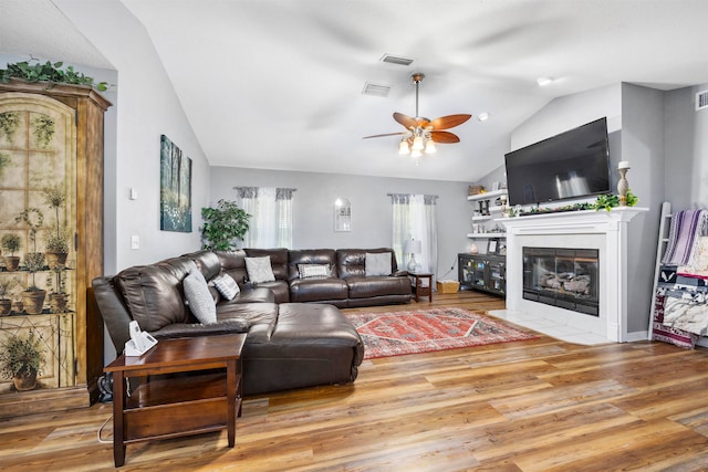 living room featuring ceiling fan, light hardwood / wood-style flooring, and lofted ceiling