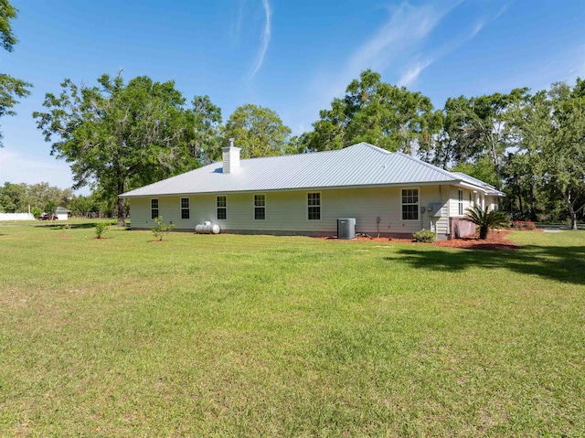 rear view of house featuring a yard and cooling unit