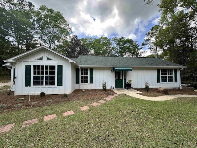 single story home with a front lawn and board and batten siding