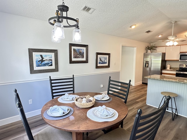 dining space with dark wood-style flooring, baseboards, ceiling fan, and visible vents