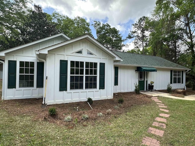 view of front facade featuring board and batten siding and roof with shingles