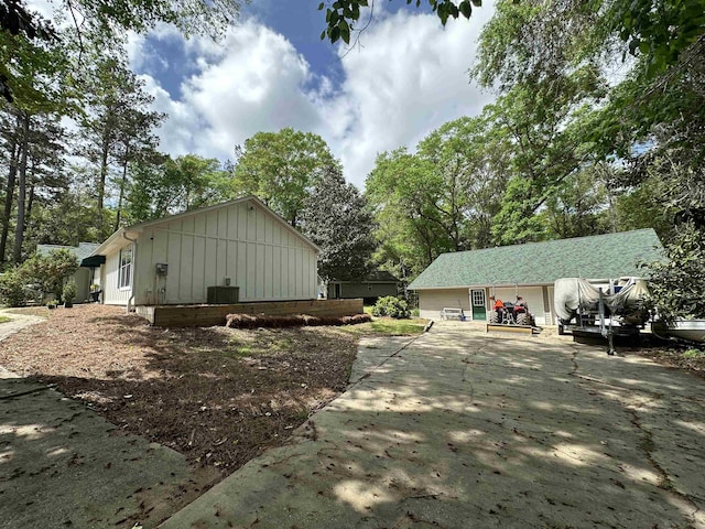 view of home's exterior with board and batten siding and concrete driveway