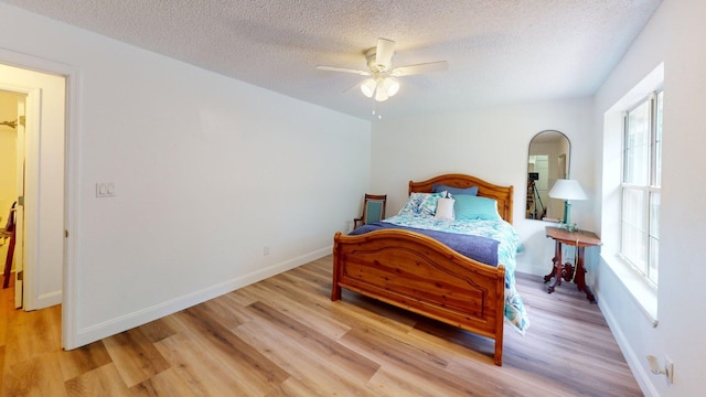 594 Green Oaks Rd, Havana, FL 32333 - bedroom with light wood-style flooring, multiple windows, a textured ceiling, and arched walkways