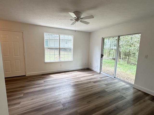 unfurnished room featuring baseboards, wood finished floors, and a ceiling fan