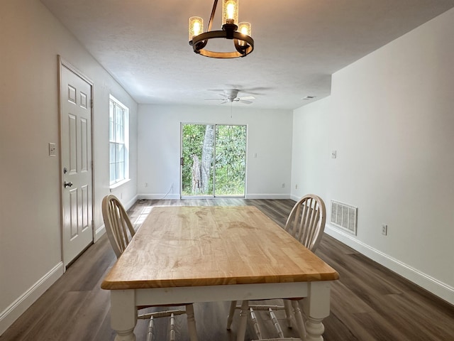 dining area featuring dark wood-type flooring, baseboards, and visible vents