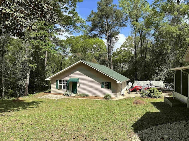 view of home's exterior featuring a lawn and a sunroom
