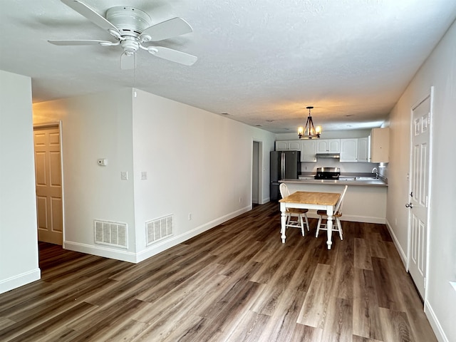 dining area featuring dark wood-style floors, visible vents, and baseboards