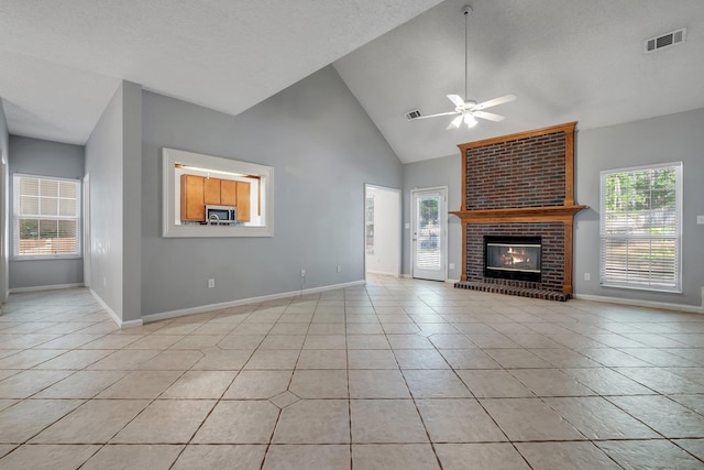 1520 Breamstone Rdg, Tallahassee, FL 32312 - unfurnished living room with light tile patterned floors, ceiling fan, baseboards, a brick fireplace, and high vaulted ceiling