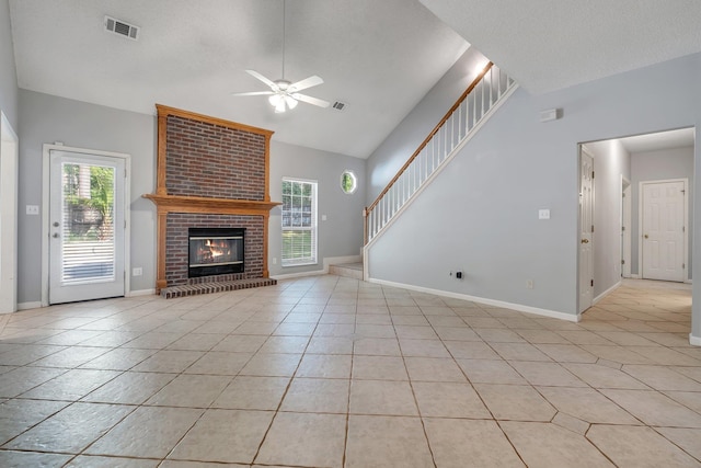 1520 Breamstone Rdg, Tallahassee, FL 32312 - unfurnished living room featuring a ceiling fan, lofted ceiling, light tile patterned floors, a brick fireplace, and stairs