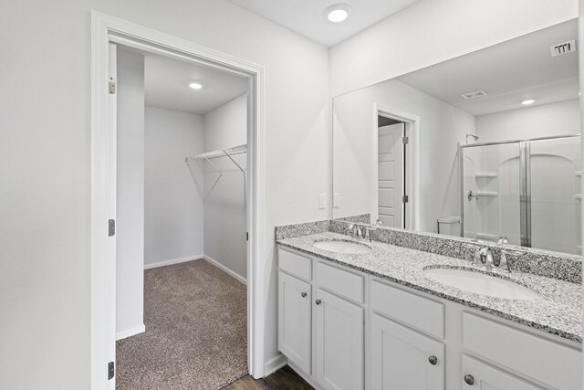 bathroom with vanity, toilet, and a shower with door