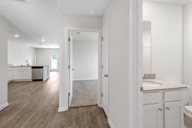 hall with light hardwood / wood-style floors and sink