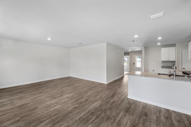 kitchen with white cabinetry, light stone countertops, sink, and dark hardwood / wood-style floors