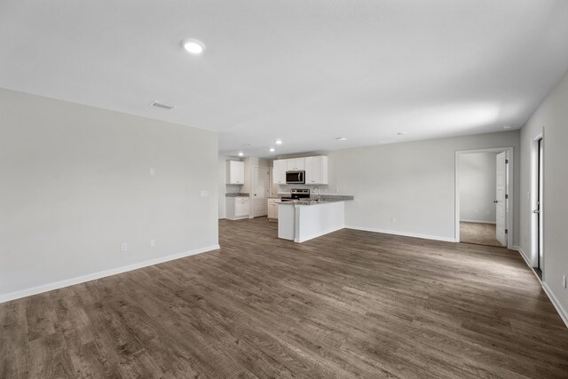 unfurnished living room with dark hardwood / wood-style flooring