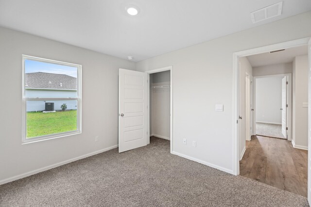 unfurnished bedroom with a closet and hardwood / wood-style flooring