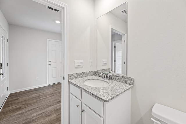 bathroom featuring hardwood / wood-style floors, vanity, and toilet