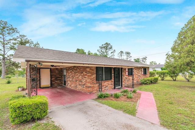 105 Goff St, Perry, FL 32347 - ranch-style home with asphalt driveway, a front lawn, a carport, brick siding, and a shingled roof