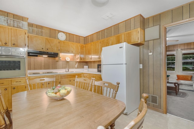 105 Goff St, Perry, FL 32347 - kitchen with white appliances, under cabinet range hood, a sink, wooden walls, and light countertops