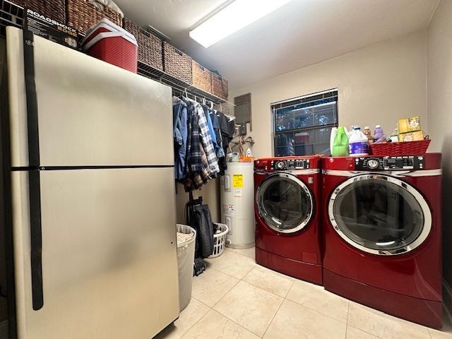 laundry room featuring light tile patterned flooring, electric water heater, and washer and clothes dryer