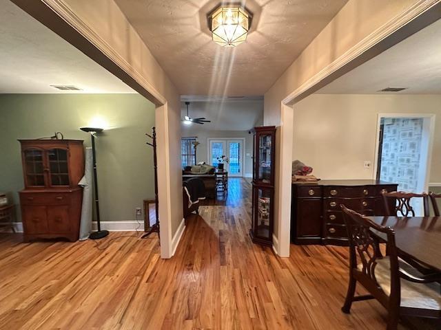 hall with french doors and light wood-type flooring