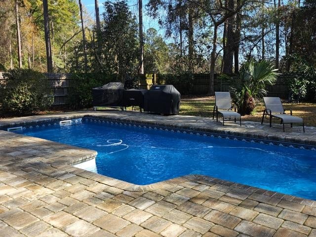 view of swimming pool featuring area for grilling and a patio