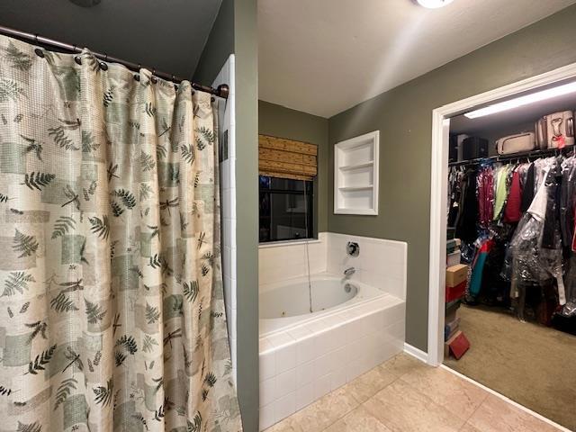 bathroom with tiled bath and tile patterned floors