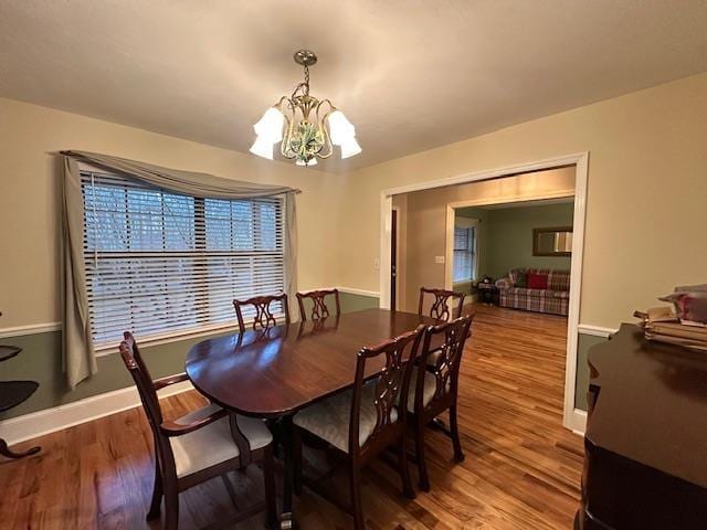 dining room with hardwood / wood-style floors and a notable chandelier