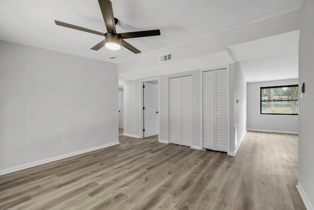 2309 Oxford Rd, Tallahassee, FL 32304 - unfurnished bedroom with two closets, wood finished floors, baseboards, and a ceiling fan