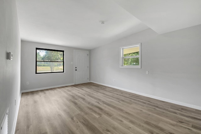 2309 Oxford Rd, Tallahassee, FL 32304 - spare room featuring plenty of natural light, wood finished floors, vaulted ceiling, and baseboards