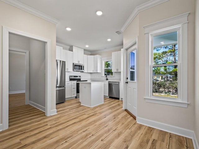 kitchen featuring white cabinets, a kitchen island, light hardwood / wood-style floors, and appliances with stainless steel finishes